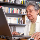 Elderly woman sitting at a laptop